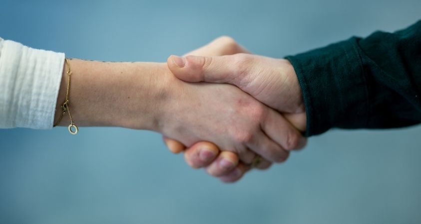 Zwei Personen geben sich die Hand