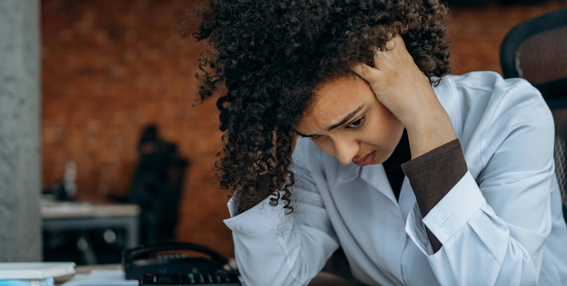 Zweifelnde Frau, die sich auf Tisch aufstützt Zweifelnde Frau, die sich auf Tisch aufstützt