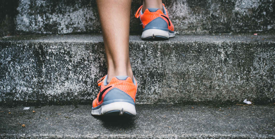 Person läuft mit Sportschuhen eine Treppe hoch